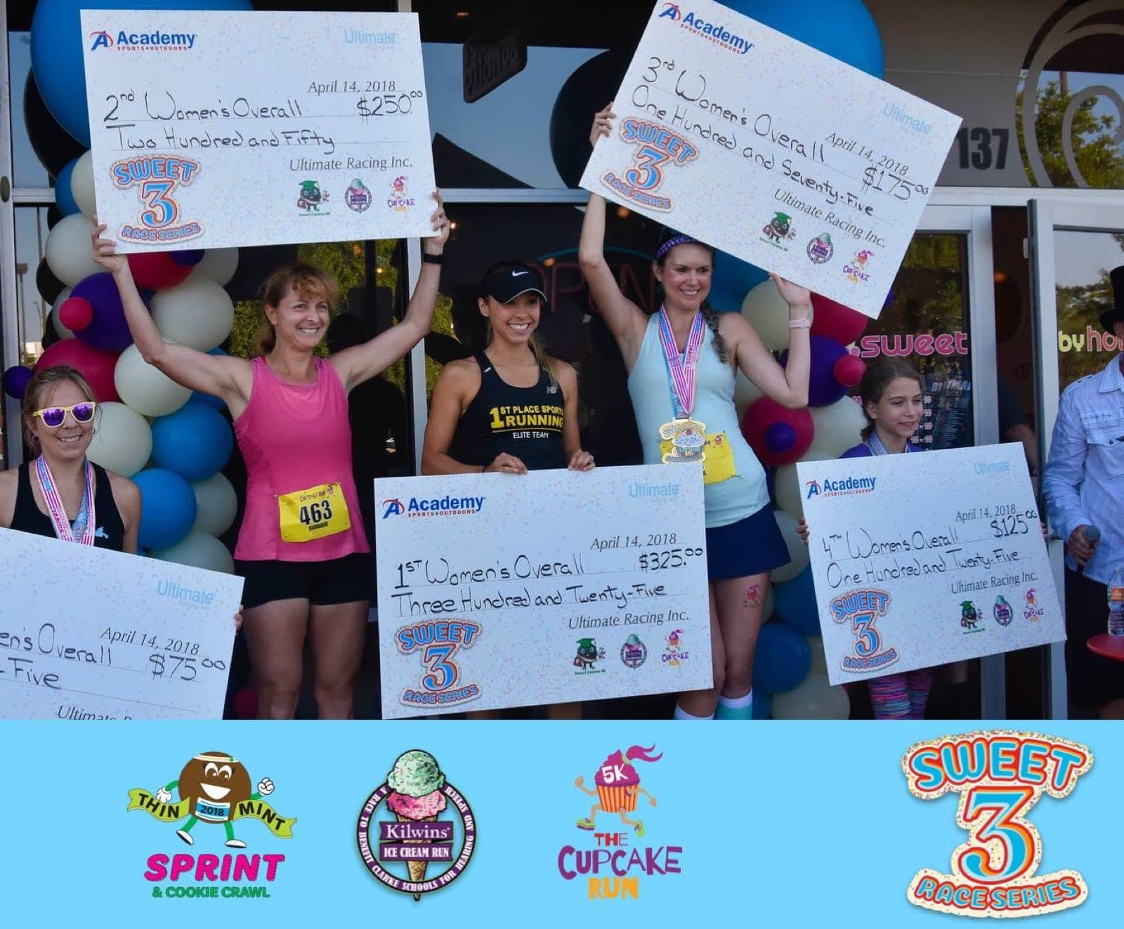 Award winners holding oversized prize checks on a podium