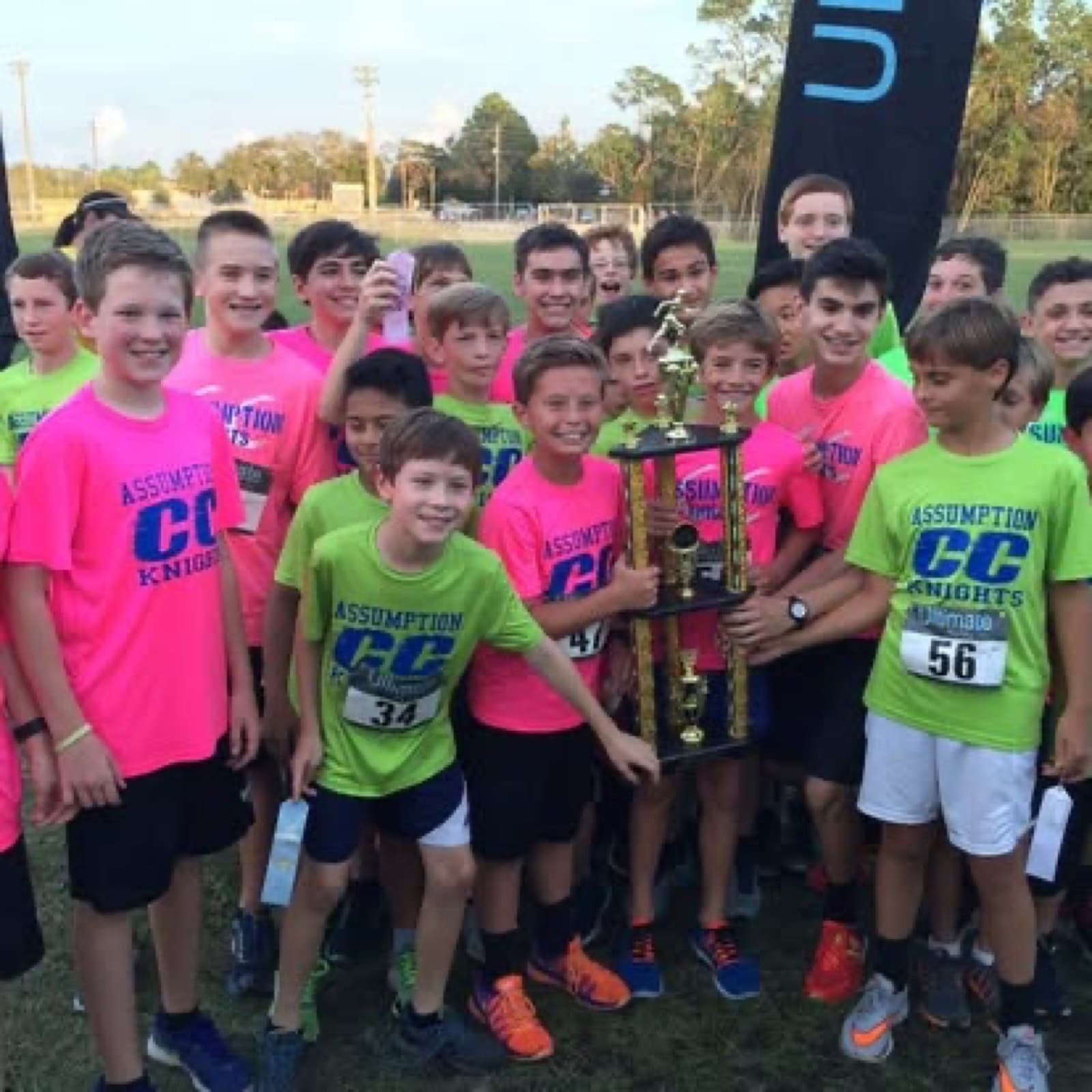 A cross country team celebrating with a trophy