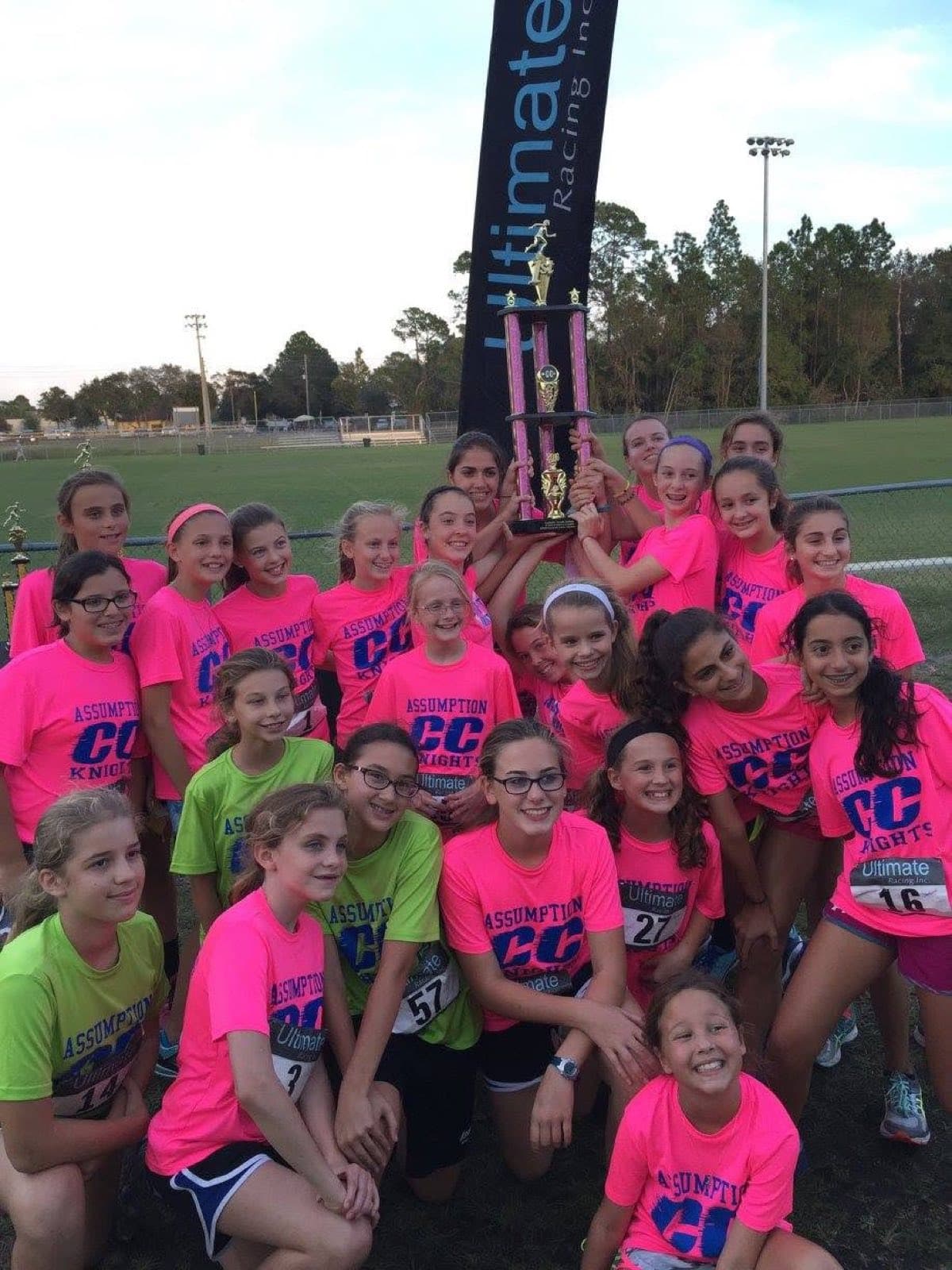 Runners posing with a championship trophy