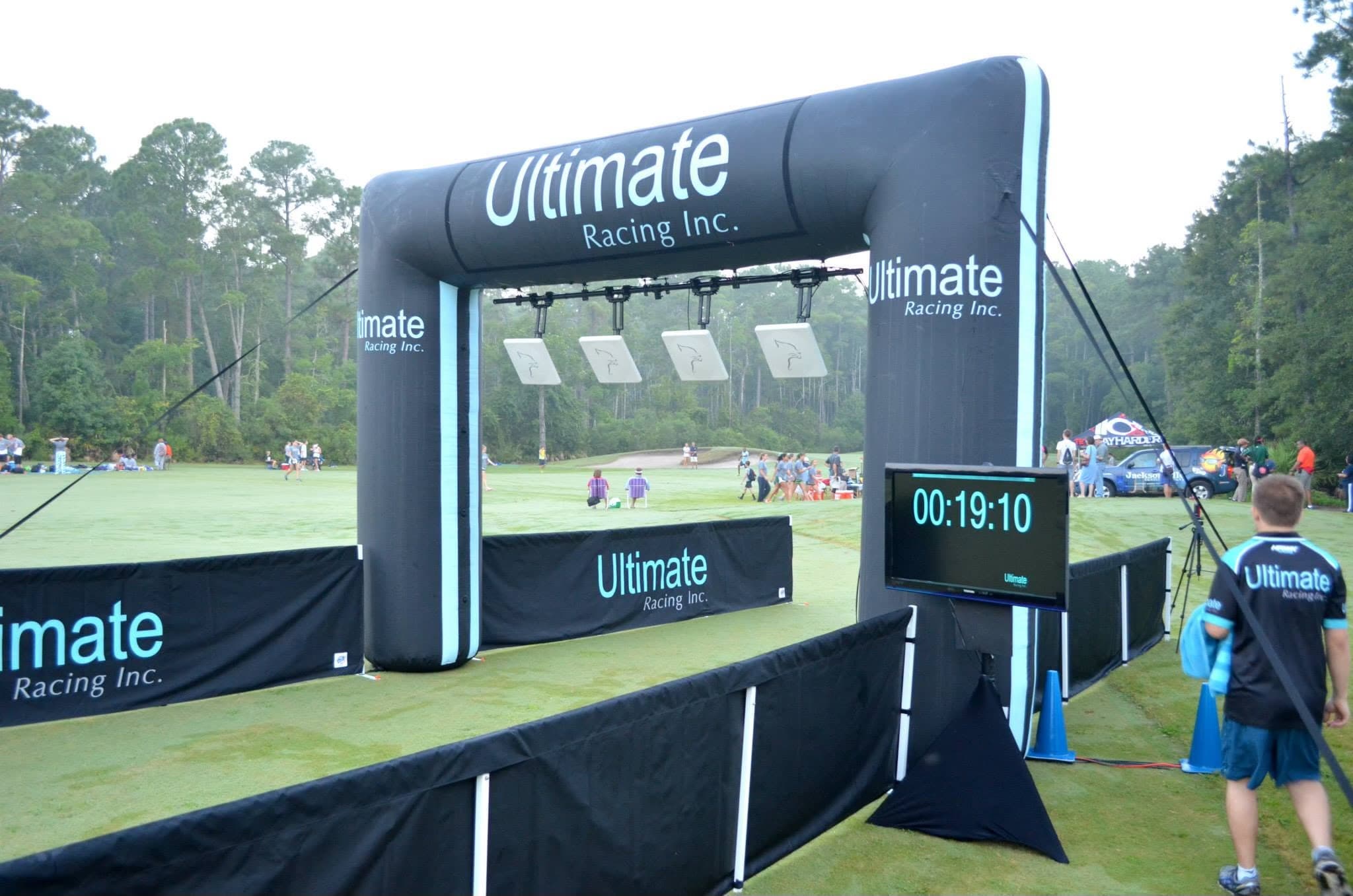 Inflatable finish line arch with overhead RFID timing antennas and race clock set up by Ultimate Racing at a Florida event