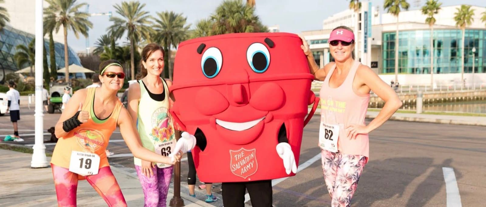A costumed mascot cheering on runners at a charity run
