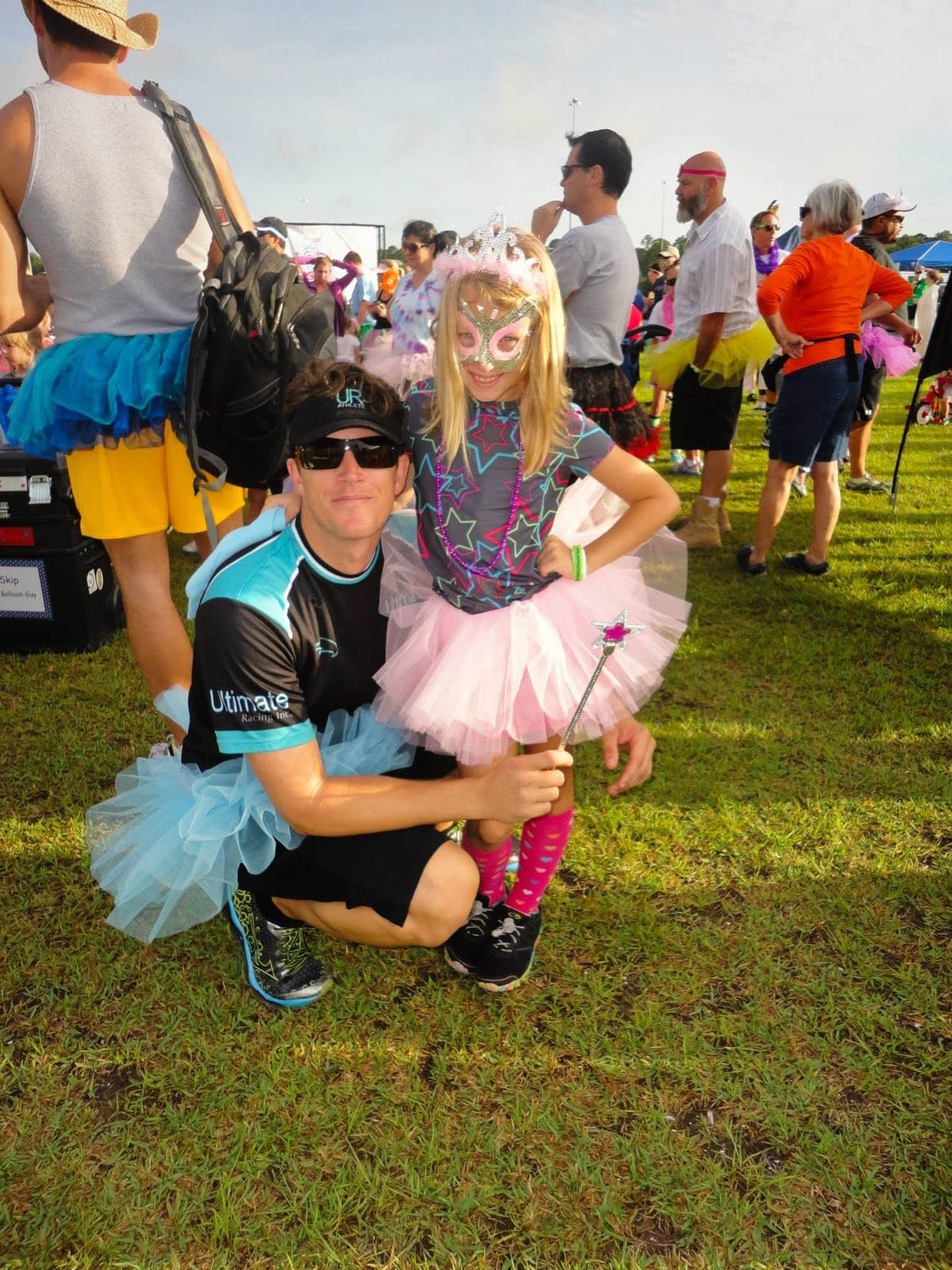 Sal Palmieri kneeling beside a young Meredith Palmieri, both wearing tutus, at a costumed charity fun run.