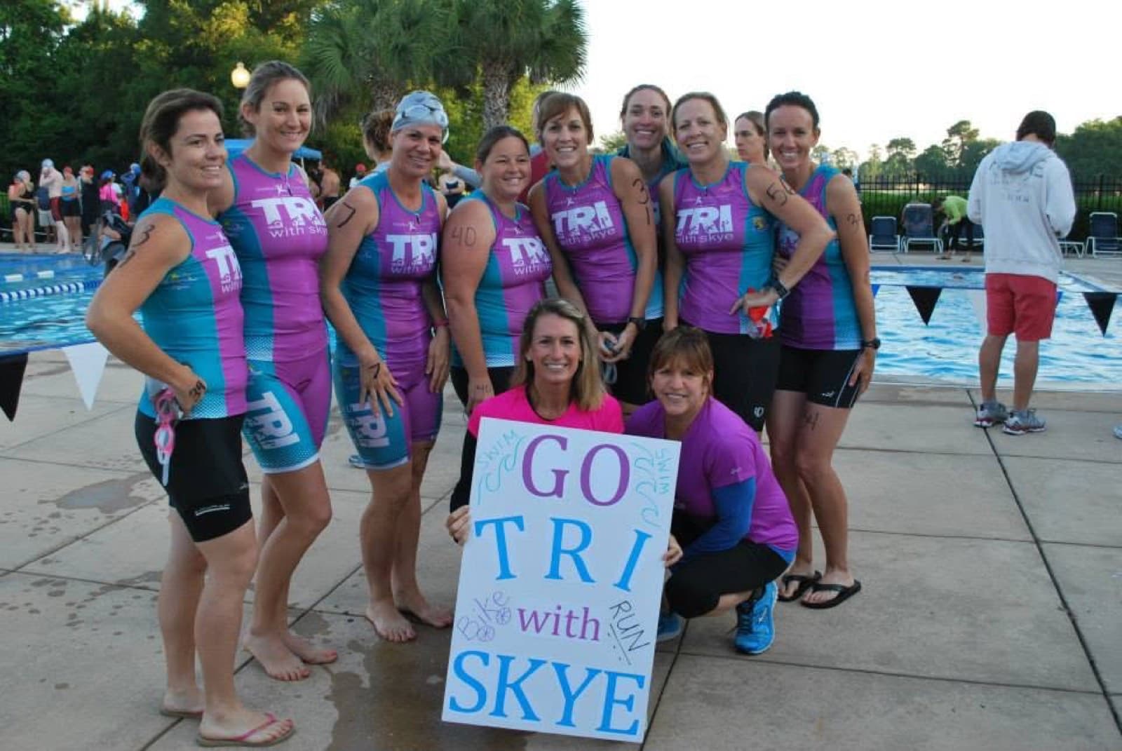 A team of triathletes in matching uniforms posing together before a race